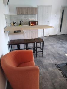 a kitchen with an orange chair and a counter at Apartmány Vihorlat III in Kaluža