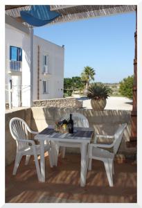 un tavolo bianco e 2 sedie su un patio di Appartamenti Mirabella a Favignana