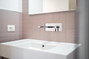 uma banheira branca na casa de banho com um espelho em La casa sul muraglione em Termoli