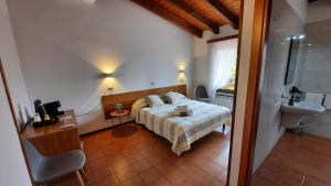 1 dormitorio con cama y lavamanos en Elisa Holidays, en Puegnago sul Garda