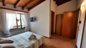een slaapkamer met een bed met een knuffeldier erop bij Elisa Holidays in Puegnago