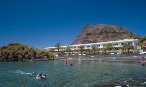 a group of people in the water at a beach at Apartamentos Charco del Conde in Valle Gran Rey