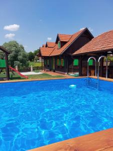 a large blue swimming pool in front of a house at KUĆA ZA ODMOR MALI DVORI in Začretje