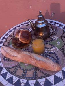 - une table avec une théière et une assiette de nourriture dans l'établissement La Symbiose Essaouira, à Essaouira