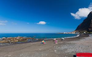 two children playing on a beach with the ocean at Apartamentos Charco del Conde in Valle Gran Rey