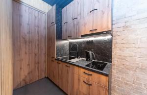a kitchen with wooden cabinets and a sink at Apart Hotel on Zoloti vorota in Kyiv