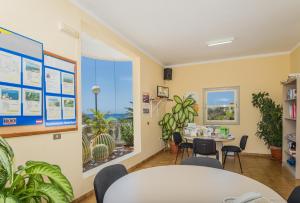 a waiting room with a table and chairs and a window at Apartamentos Charco del Conde in Valle Gran Rey