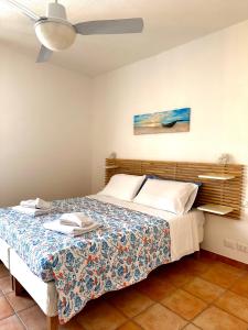 una camera con letto e ventilatore a soffitto di Dimora Saracena Forio a Ischia
