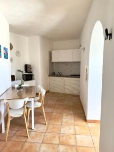 - une cuisine et une salle à manger avec une table et des chaises dans l'établissement Dimora Saracena Forio, à Ischia