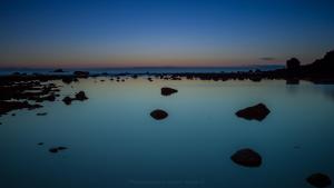 a lake with rocks in the water at night at Apartamentos Charco del Conde in Valle Gran Rey
