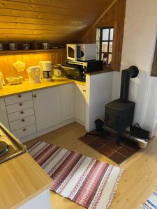 a kitchen with a stove in the middle of a room at Bjørkely gård in Hidra