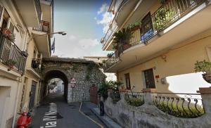 an alley way between two buildings with an archway at A&M Home in Letojanni