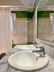 a bathroom with a sink and a large mirror at Down town villa Kavala in Kavala
