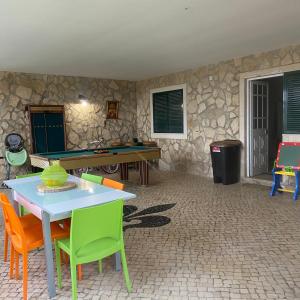 einen Tisch und Stühle in einem Zimmer mit einer Steinmauer in der Unterkunft Venus House in Lamas
