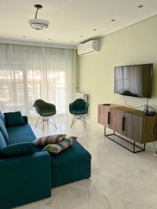 sala de estar con sofá azul y TV de pantalla plana en Down town villa Kavala en Kavala