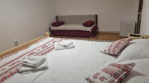 - une chambre avec un grand lit et des serviettes dans l'établissement Pensiunea Poienita Motilor, à Achimeţeşti