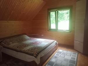 sypialnia z łóżkiem w drewnianym domku w obiekcie Під горою w mieście Szeszory