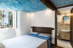 1 dormitorio con 1 cama y techo azul en CINQUE TERRE Hiking, Trekking & Relax, en Biassa