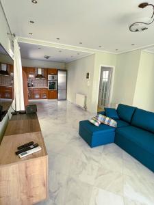 sala de estar con sofá azul y cocina en Down town villa Kavala, en Kavala