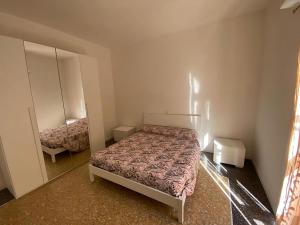 - une petite chambre avec un lit et un miroir dans l'établissement GG Apartment Salò, à Salò