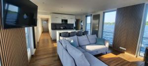 a living room with a large couch and a kitchen at Hausboot Amantes in Brandenburg an der Havel