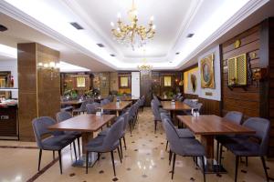 a restaurant with wooden tables and chairs and a chandelier at Grand Ant Hotel in Istanbul