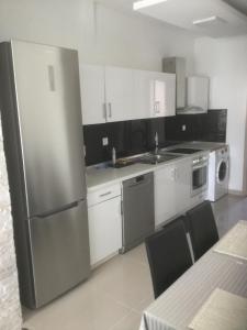a kitchen with a stainless steel refrigerator and white cabinets at Chrystal Boutique Suite in Skala Marion