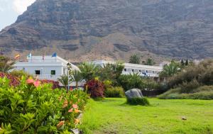 a view of a building with a mountain in the background at Apartamentos Charco del Conde in Valle Gran Rey