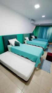 three beds in a room with green walls at ALQUIMIA in Paso de la Patria