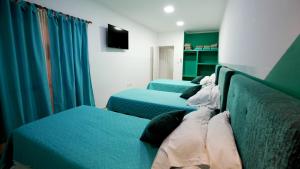 3 Betten in einem Zimmer mit grünen Vorhängen in der Unterkunft ALQUIMIA in Paso de la Patria