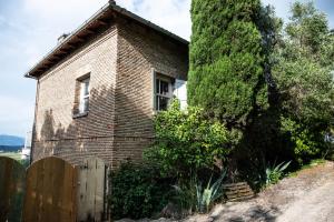 una casa de ladrillo con una valla y un árbol en Guesthouse Elena , Vatos, Corfu, en Vátos