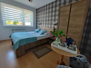 a small bedroom with a bed and a table at Villa Karo in Łeba