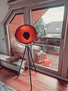 a red fan sitting on a tripod in front of a window at Rosindell Brunnenhaus in Halle Westfalen