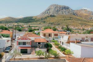 eine Stadt mit Häusern und einem Berg im Hintergrund in der Unterkunft AKANTHOS Rental House in Kórinthos