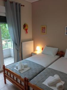 a bedroom with two beds and a window with a view at Sofia's Garden in Nea Peramos