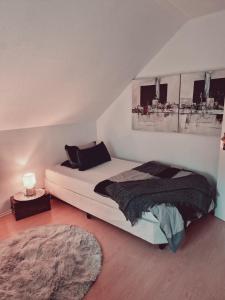 ein Schlafzimmer mit einem Bett und einem Tisch mit einer Lampe in der Unterkunft Rosindell Brunnenhaus in Halle Westfalen