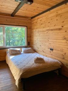 ein Schlafzimmer mit einem Bett in einer Holzhütte in der Unterkunft Воллен in Zhvanets