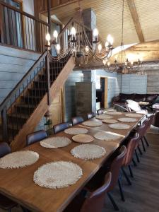 a long wooden table with chairs and a staircase at Rovanperän kelomökit in Syöte