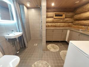 een badkamer met een wastafel, een douche en een toilet bij Rovanperän kelomökit in Syöte