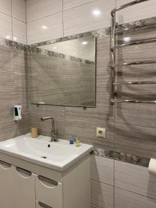 een badkamer met een wastafel en een douche met een spiegel bij Воллен in Zhvanets