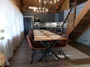 a long dining room table with chairs and a chandelier at Rovanperän kelomökit in Syöte
