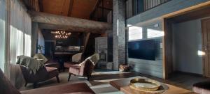 a living room with a fireplace and a tv at Rovanperän kelomökit in Syöte