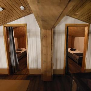 een kamer met 2 spiegels en 2 bedden bij Rovanperän kelomökit in Syöte