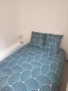 - une chambre avec un lit doté d'un couvre-lit bleu et blanc dans l'établissement T2 confortable au coeur de Laval, à Laval