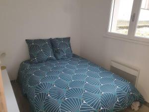 - une chambre avec un lit doté d'une couette bleue et d'une fenêtre dans l'établissement T2 confortable au coeur de Laval, à Laval