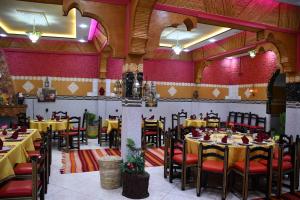 a restaurant with tables and chairs in a room at Hôtel La Vallée Des Oiseaux in Boumalne