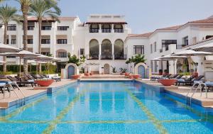 a swimming pool in front of a hotel at 1 Bedroom Suite @ The address Golf Marassi Resort in El Alamein