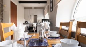 a dining room table with glasses and plates on it at Windermere in Sawrey