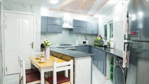 cocina con armarios azules y mesa de madera en Appartement luxe au centre ville, en Annaba