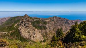 a rocky mountain with the ocean in the background at Apartamentos Charco del Conde in Valle Gran Rey